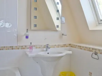 a white bathroom with a sink and a mirror at Waterside in Tighnabruaich