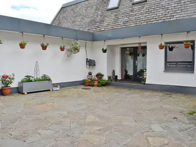 a patio with potted plants on the side of a building at Waterside in Tighnabruaich