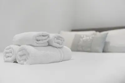 a stack of towels sitting on top of a bed at Upper Grove 2 Bedroom Apartment - Edinburgh in Edinburgh