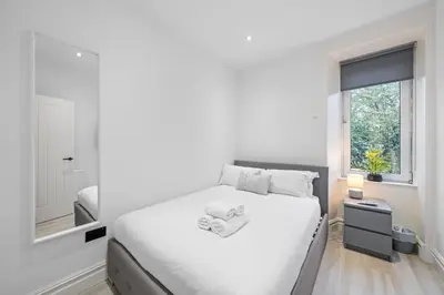 a white bedroom with a large bed and a window at Upper Grove 2 Bedroom Apartment - Edinburgh in Edinburgh