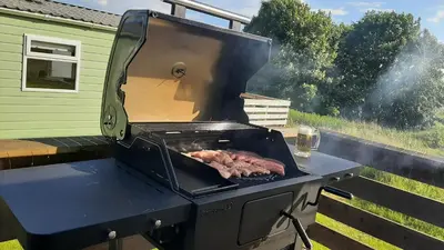 a grill with meat cooking on top of it at Lochview Retreat Caravan in Balminnoch