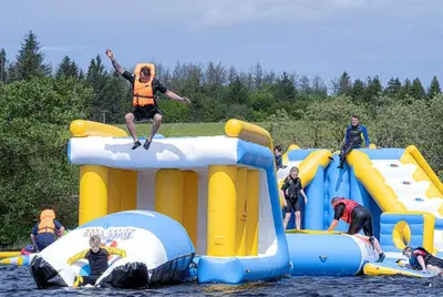 a group of people playing on an inflatable raft at Lochview Retreat Caravan in Balminnoch