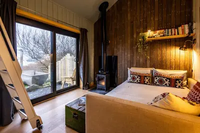 a bedroom with a bed and a large window at Jura - The Rusty Hut in Craighouse