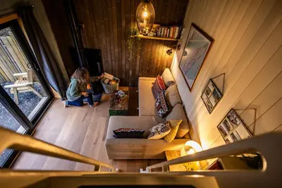 a woman is sitting in a living room at Jura - The Rusty Hut in Craighouse