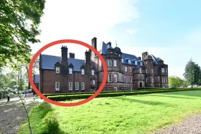 a red circle in front of a large building at 20 The Courtyard, Ballochmyle House in Mauchline