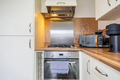 a kitchen with a stove and a microwave at Bright, modern 2 bedroom house with free parking! in Edinburgh