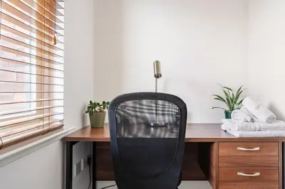 a black chair sitting at a desk in a room at Bright, modern 2 bedroom house with free parking! in Edinburgh