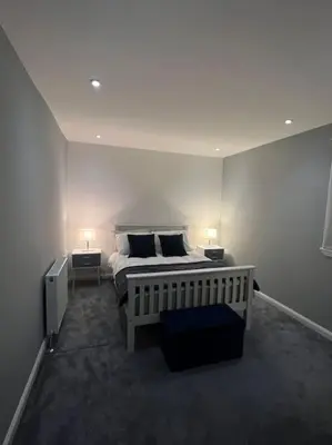 a bedroom with a bed with two lamps on it at Ardenslate House in Kirn