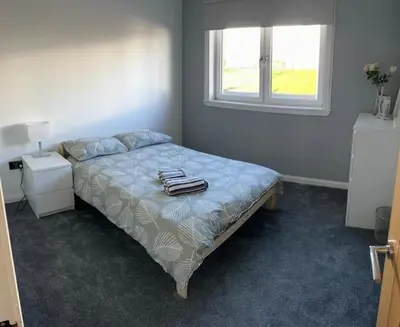 a bedroom with a bed with towels on it at Ardenslate House in Kirn