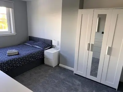 a small bedroom with a bed and a shower at Ardenslate House in Kirn
