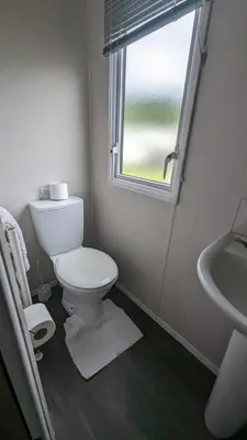 a bathroom with a toilet and a sink and a window at The Brockenhurst 25 in Dunoon