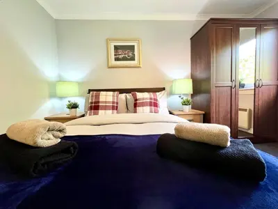 a bedroom with a large bed with two pillows at Spacious 2 Bed-Flat in Glasgow City - Free Parking in Glasgow