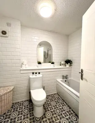 a bathroom with a toilet and a tub and a mirror at Spacious 2 Bed-Flat in Glasgow City - Free Parking in Glasgow