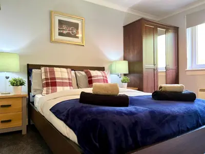 a bedroom with a large bed with two pillows on it at Spacious 2 Bed-Flat in Glasgow City - Free Parking in Glasgow