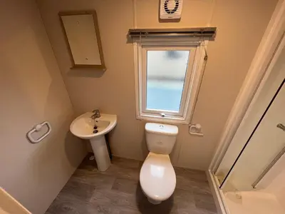 a small bathroom with a toilet and a sink at Newton Stewart - Lodge - Sleeps 4 - Garden in Bargrennan