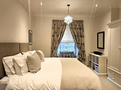 a bedroom with a large white bed with a window at Edinburgh Elegant 1-Bedroom City Apartment in Edinburgh