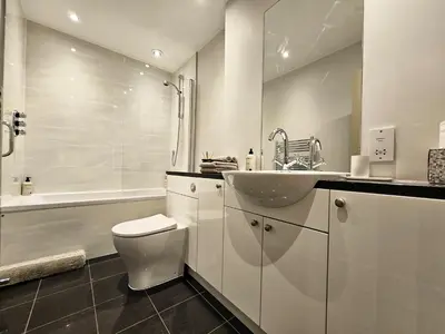 a white bathroom with a sink and a toilet at Edinburgh Elegant 1-Bedroom City Apartment in Edinburgh