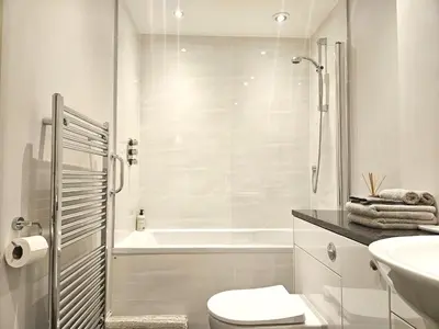 a bathroom with a toilet and a tub and a sink at Edinburgh Elegant 1-Bedroom City Apartment in Edinburgh