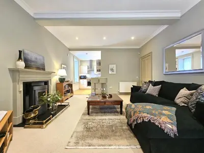 a living room with a green couch and a fireplace at Edinburgh Elegant 1-Bedroom City Apartment in Edinburgh
