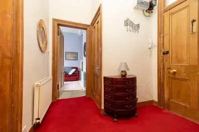 a hallway with a red carpet and a wooden door at Charming 1-Bedroom Edinburgh City Getaway in Edinburgh