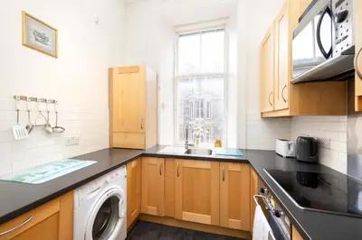 a kitchen with a washer and dryer on a counter at Charming 1-Bedroom Edinburgh City Getaway in Edinburgh