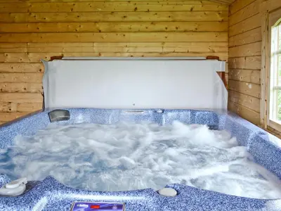 a jacuzzi tub in a wooden room at Fingask Log Cabin - S4394 in Glenfarg