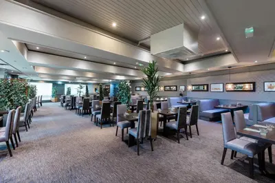 a restaurant with tables and chairs in a room at Normandy Hotel (Near Glasgow Airport) in Paisley