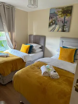 a bedroom with two beds with towels on them at HLA king court 3 in Motherwell
