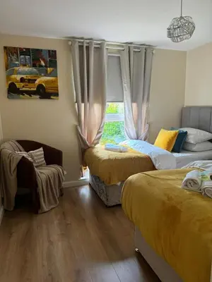 a bedroom with two beds and a window at HLA king court 3 in Motherwell