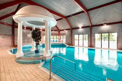 a large indoor pool with a large swimming pool at Glynhill Hotel & Spa near Glasgow Airport in Paisley