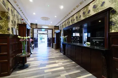 a hallway with a bar in a restaurant with flowers at Glynhill Hotel & Spa near Glasgow Airport in Paisley