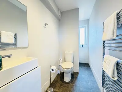 a white bathroom with a toilet and a sink at Skyline View Apartment in Edinburgh