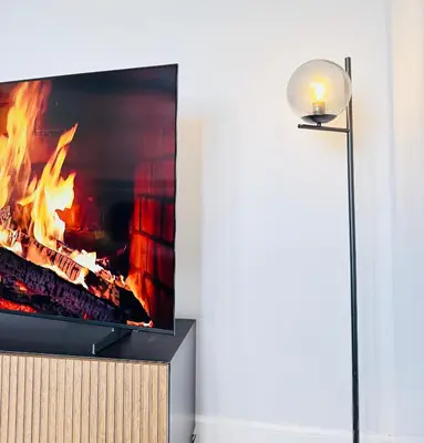 a flat screen tv sitting on a stand next to a fire at Skyline View Apartment in Edinburgh
