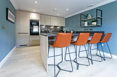 a kitchen with orange chairs at a counter at Troon No 1 Apartments in Troon