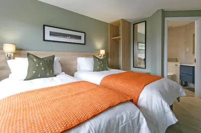 a bedroom with two beds with an orange blanket at Troon No 1 Apartments in Troon