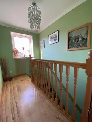 a staircase in a home with green walls and a chandelier at Stunning 3 bedroom house with 2 bathrooms in Mansewood