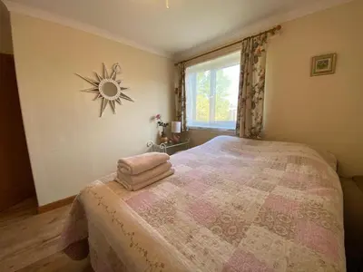 a bedroom with a large bed and a window at Stunning 3 bedroom house with 2 bathrooms in Mansewood