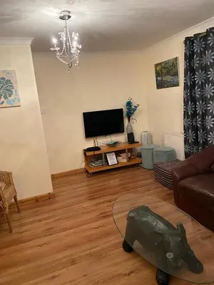 a living room with a couch and a flat screen tv at Stunning 3 bedroom house with 2 bathrooms in Mansewood