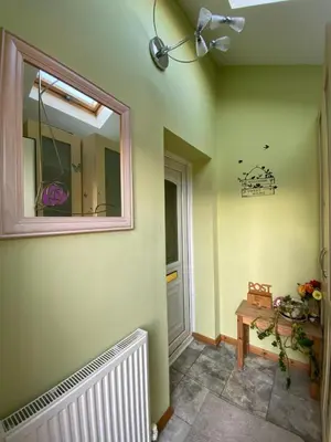 a hallway with a mirror on the wall and a table at Stunning 3 bedroom house with 2 bathrooms in Mansewood