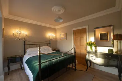 a bedroom with a bed and a mirror at Milton House in Buchanty