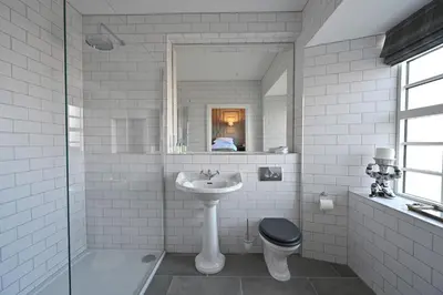 a white bathroom with a sink and a toilet at Milton House in Buchanty