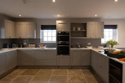 a large kitchen with white cabinets and appliances at The Old Farmhouse in Buchanty