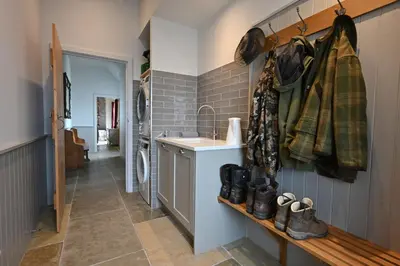 a kitchen with a sink and a counter with shoes at Falcon Steading in Buchanty