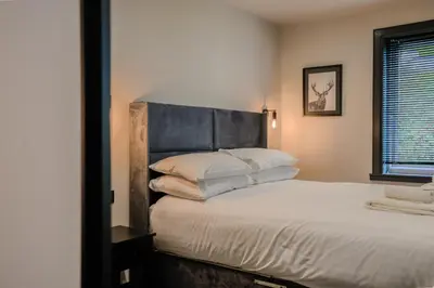 a bedroom with a large bed with white sheets and pillows at The Righ in Oban