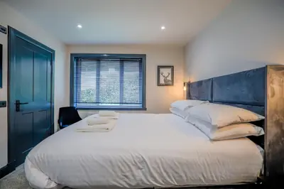a bedroom with a large white bed with a blue headboard at The Righ in Oban