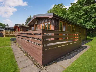a tiny house in a yard with a fence at Lomond View Lodge in Rowardennan