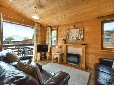 a living room with a couch and a fireplace at Lomond View Lodge in Rowardennan