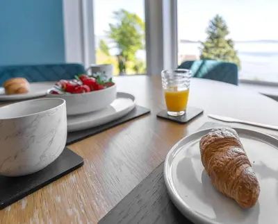 a table with a plate of food and a cup of orange juice at The Bayview, Rothesay, Isle of Bute in Rothesay