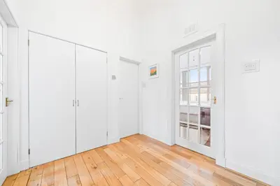 an empty room with white walls and wooden floors at Perfect location for beach and golfing in Troon