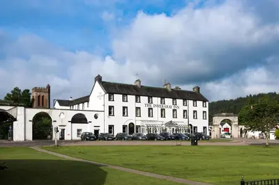 a large white building with cars parked in front of it at The Inveraray Inn, BW Signature Collection in Inveraray
